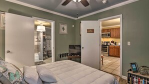 A bedroom with a bed, a ceiling fan, a bedside table, and a bookshelf.