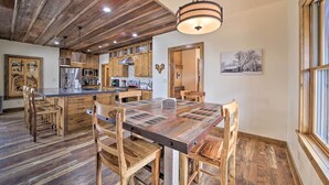 Una cocina rústica con armarios de madera, una isla central y una mesa de comedor con sillas.