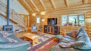 A log cabin interior with a fireplace, sofa, and a television. - 13 Mi to Mt Shasta: Log Home on 60 Acres! (McCloud)