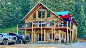 A log cabin with a stone foundation, a balcony with outdoor seating, and a flag. - 13 Mi to Mt Shasta: Log Home on 60 Acres! (McCloud)