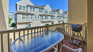 A balcony with a glass table, a grill, and a view of multi-story buildings. - Townhome w/ Balcony < 1 Mi to Wildwood Crest Bch! (Wildwood Crest)