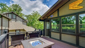 Une terrasse avec un jacuzzi, un panneau indiquant la présence d’un restaurant et une vue sur un terrain de golf.
