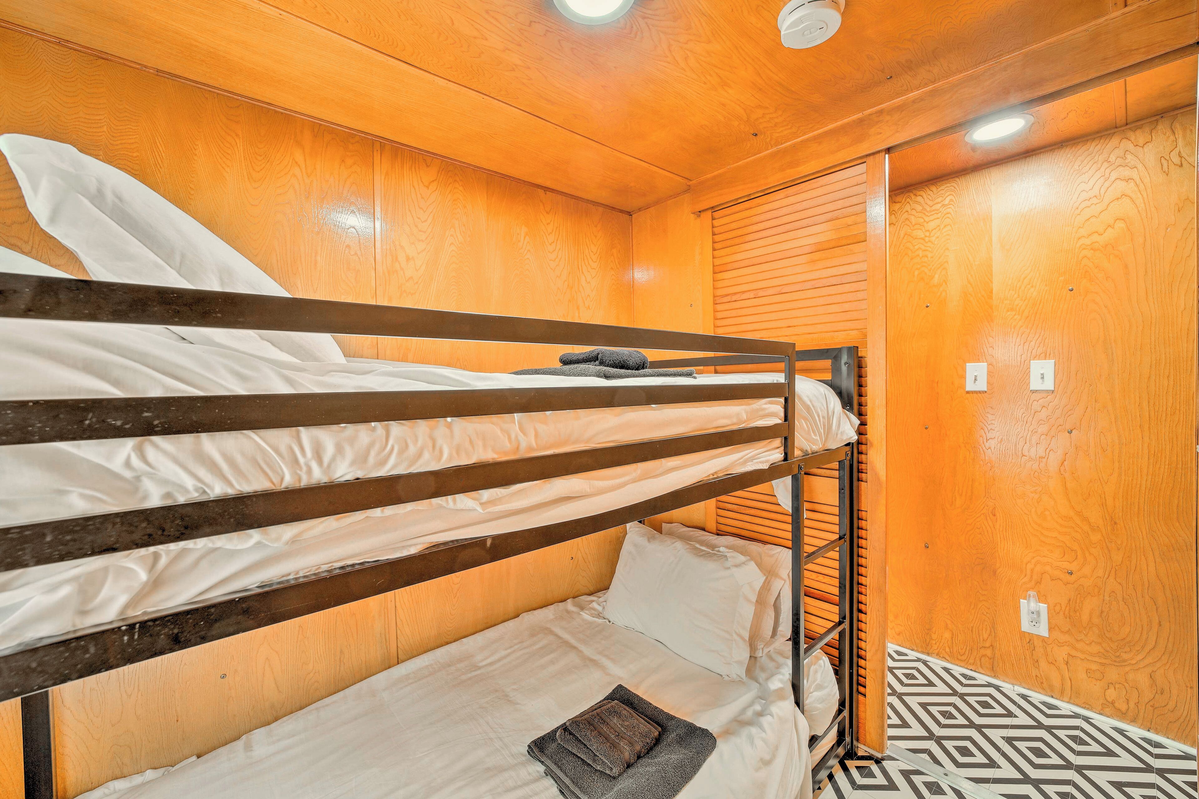 A bunk bed room with wooden walls and a patterned floor.