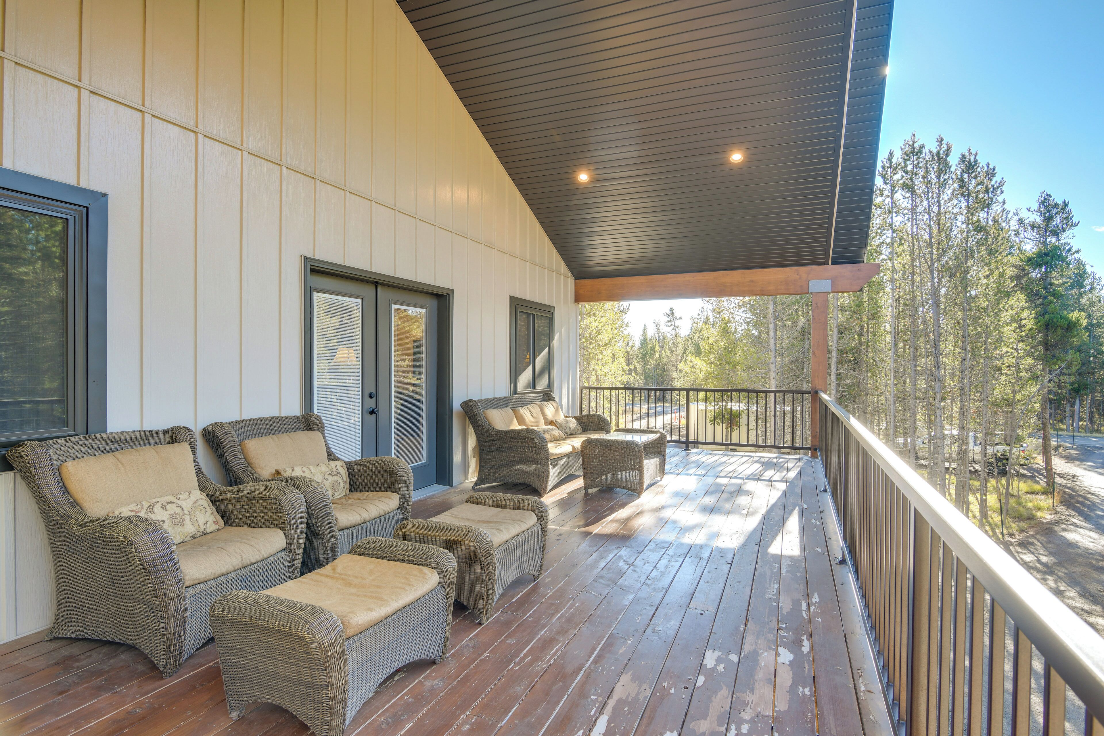 A covered porch with wicker furniture and a wooden deck.