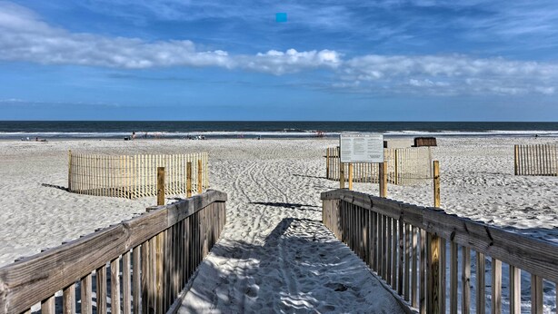 A wooden boardwalk leading to a sandy beach with a clear sky. - Steps to Pool & Beach: Family Condo in Hilton Head (Hilton Head Island)