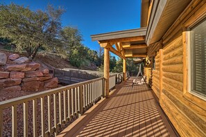 A wooden deck with a railing, a stone wall, and a view of trees and hills. - Stunning 3-story Mountain View Getaway in Payson (Payson)