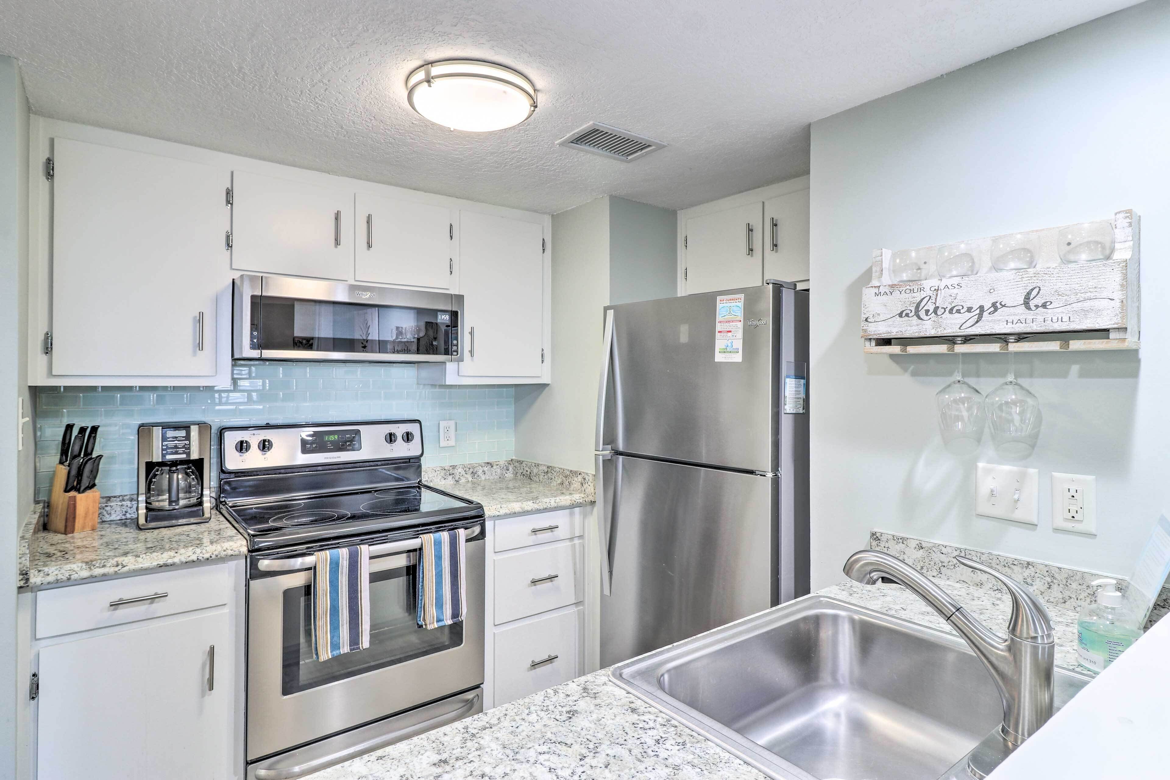 A modern kitchen with stainless steel appliances, a granite countertop, and a built-in sink.