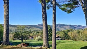 A golf course with tall trees and a mountain backdrop. - Glen Condo w/ Mountain Views: Walk to Story Land (Glen)