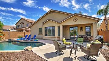 A residential property with a swimming pool, outdoor furniture, and a patio area.