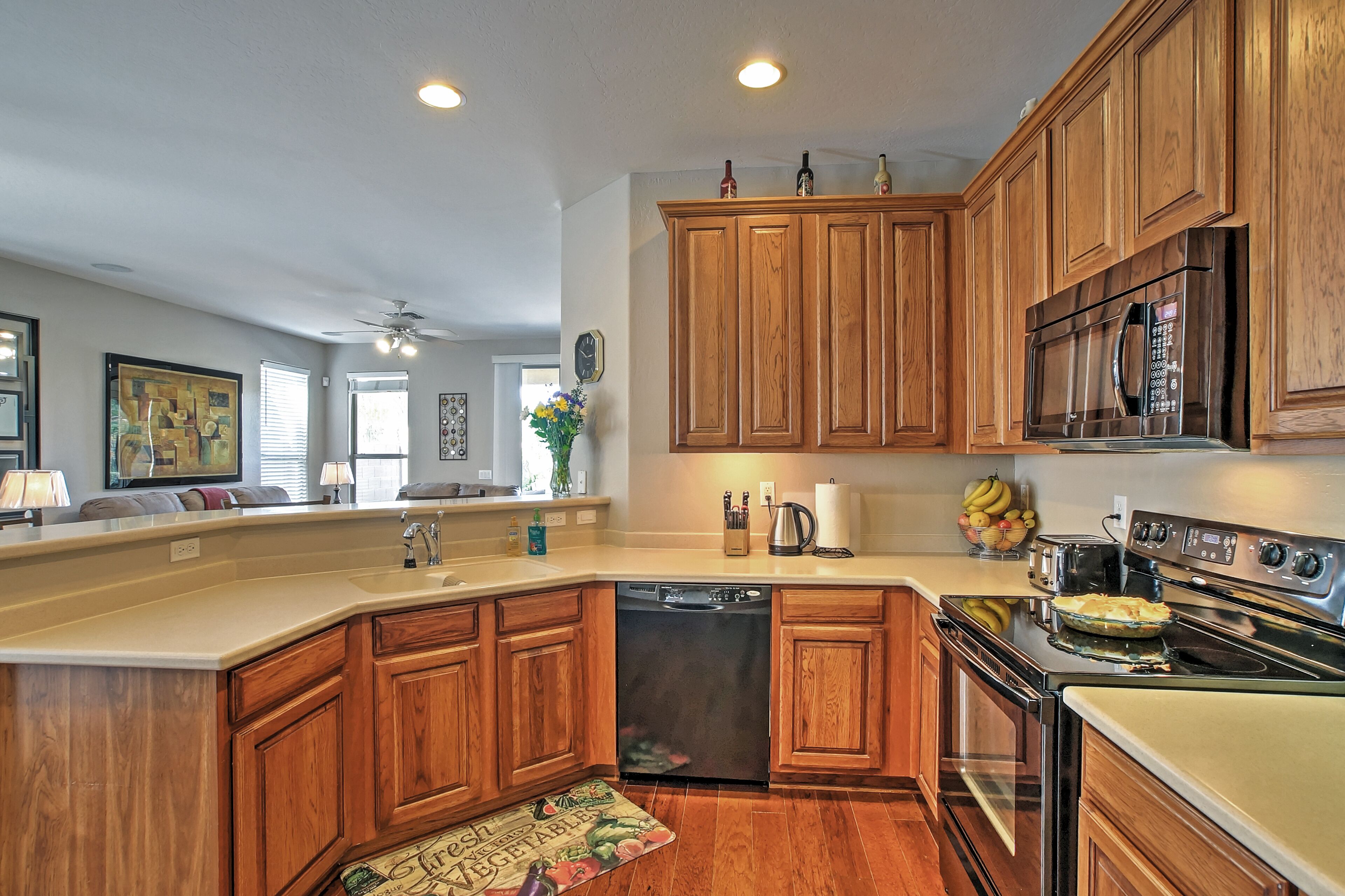 A kitchen with wooden cabinets, a dishwasher, an oven, and a microwave.
