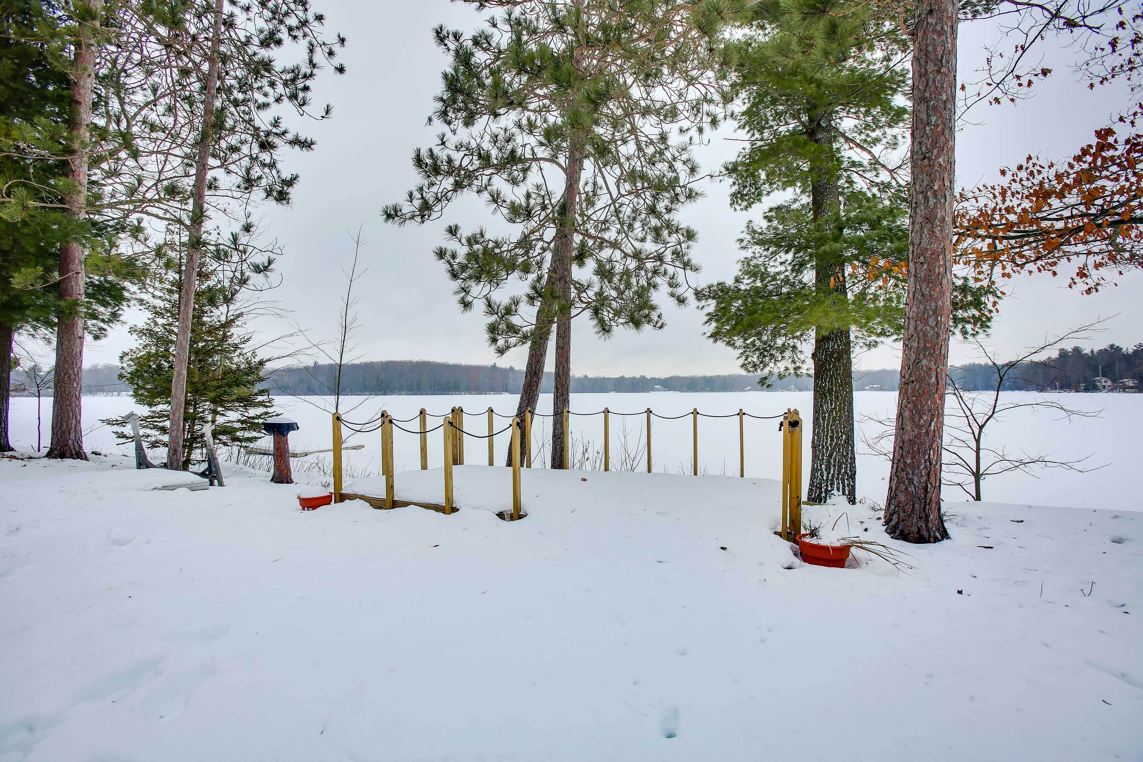 Een besneeuwd gebied met bomen en een omheind gedeelte.