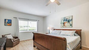 A bedroom with a wooden bed, a desk, a chair, a window with blinds, and a ceiling fan. - Gorgeous Lakefront Townhome w/ Pool Access & Views (Montgomery)