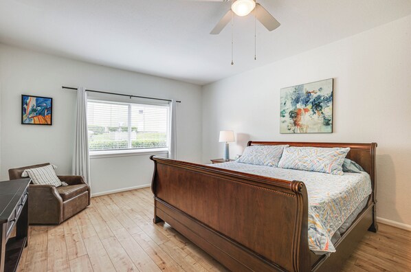 A bedroom with a wooden bed, a desk, a chair, a window with blinds, and a ceiling fan. - Gorgeous Lakefront Townhome w/ Pool Access & Views (Montgomery)