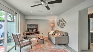 A modern living room with a ceiling fan, a sofa, a coffee table, and a TV.
