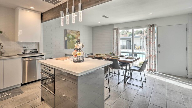 A modern kitchen with a central island, stainless steel appliances, and pendant lighting.