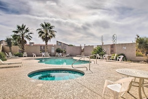 Un espace piscine avec des chaises longues et une petite table.