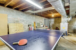 A ping pong table in a room with stone walls and exposed ceiling beams. - Hampton 'quiet Corner Cottage' w/ Fireplace & Yard (Hampton)