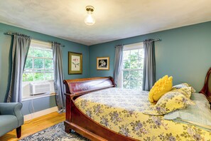 A bedroom with a bed, two windows with curtains, a radiator, and a ceiling light. - Hampton 'quiet Corner Cottage' w/ Fireplace & Yard (Hampton)