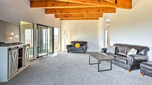 A spacious living room with a leather sofa, a coffee table, and a fireplace. - Spacious Royal Oaks Retreat w/ Deck & Views! (Watsonville)