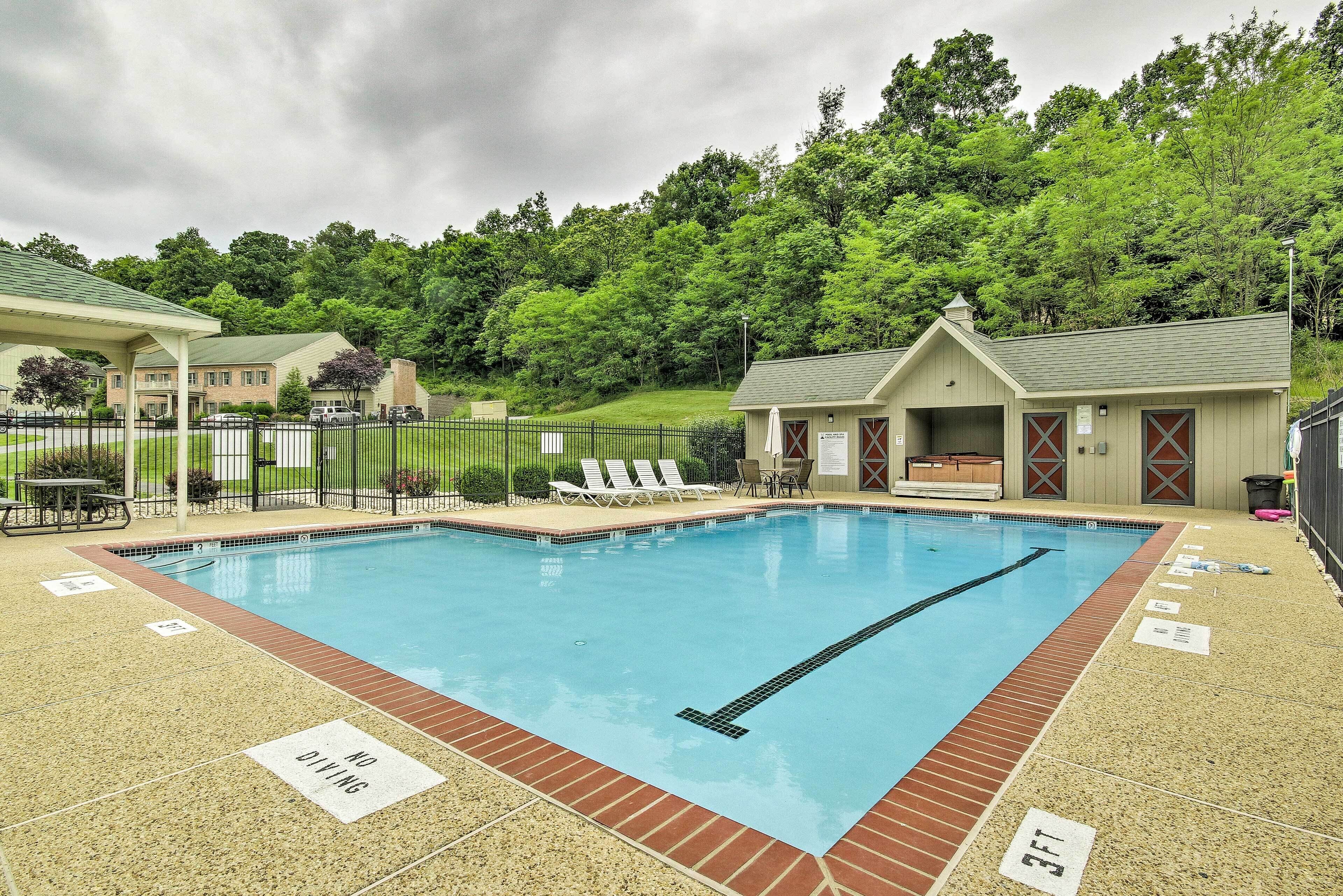 A swimming pool with a diving board, lounge chairs, and a small building with a chimney.
