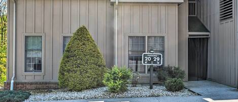 A building with a beige exterior, a large conical tree, and a parking sign indicating 20 spaces.