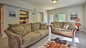 A living room with two sofas, a rug, and artwork on the walls.