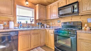 A kitchen with wooden cabinets, a stainless steel stove, a microwave, and a dishwasher.