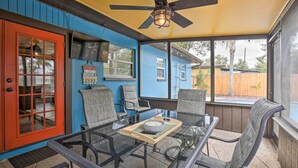 An outdoor patio with a glass table, chairs, and a ceiling fan. - Tropical Palm Harbor Retreat With Lanai & Patio! (Palm Harbor)