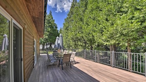 A wooden deck with outdoor furniture and a glass door leading to a room. - Secluded Camp Connell Home w/ Deck + Fireplace! (Arnold)