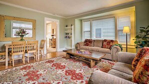 A living room with a sofa, coffee table, and a dining area with chairs and a table. - Peaceful Wine Country Getaway - Walk to Downtown! (Walla Walla)