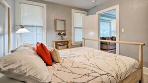 A bedroom with a bed, a nightstand, a lamp, and a window. - Peaceful Wine Country Getaway - Walk to Downtown! (Walla Walla)