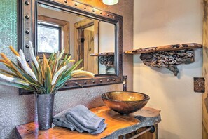 A bathroom with a large mirror, a copper bowl sink, a decorative vase with plants, and a wooden shelf with a rustic decoration. - Wooded Retreat w/ Deck: 4 Mi to Downtown Flagstaff (Flagstaff)