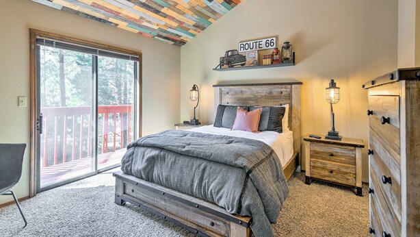 Ein Schlafzimmer mit einem großen Bett, einem Holz-Kopfteil, einem Schminktisch und einem Regal mit Route 66 Souvenirs.