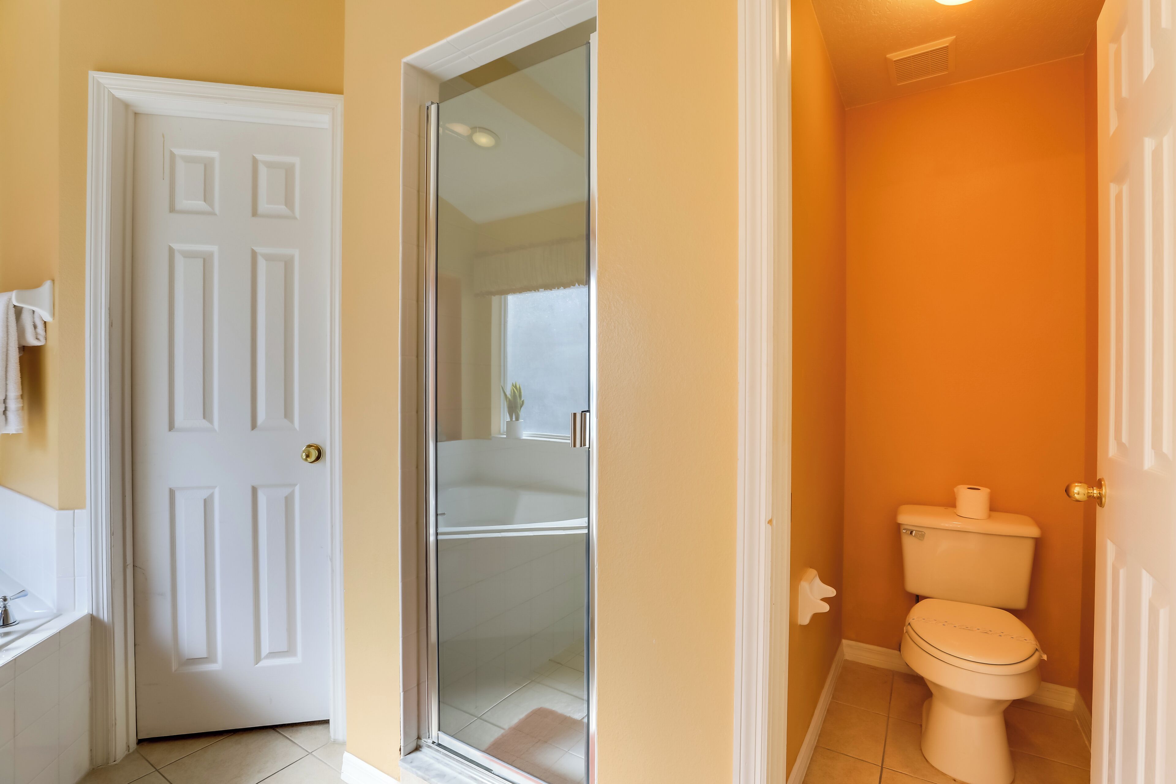A bathroom with a white toilet, a shower, and a sink.