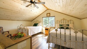 A bedroom with two beds, a wooden ceiling, a window, and a desk with a vase of flowers. - 'cabin at the Little Ranch' w/ Hiking On-site! (Bayfield)