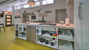 A kitchen with a central island, built-in shelves, a stove, and a sink. There are decorative antlers on the wall and a window above the sink.