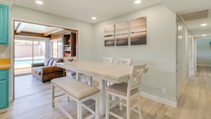 A modern kitchen with a dining area, wooden cabinets, and a view to the outside. - Location! Home w/ Pool 1 Min to Mcculloch Blvd (Lake Havasu City)
