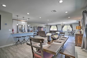 A spacious dining area with a long table, chairs, and a central decorative vase.