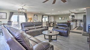 Ein geräumiges Wohnzimmer mit Ledersofas, einem Essbereich und einer Küche.