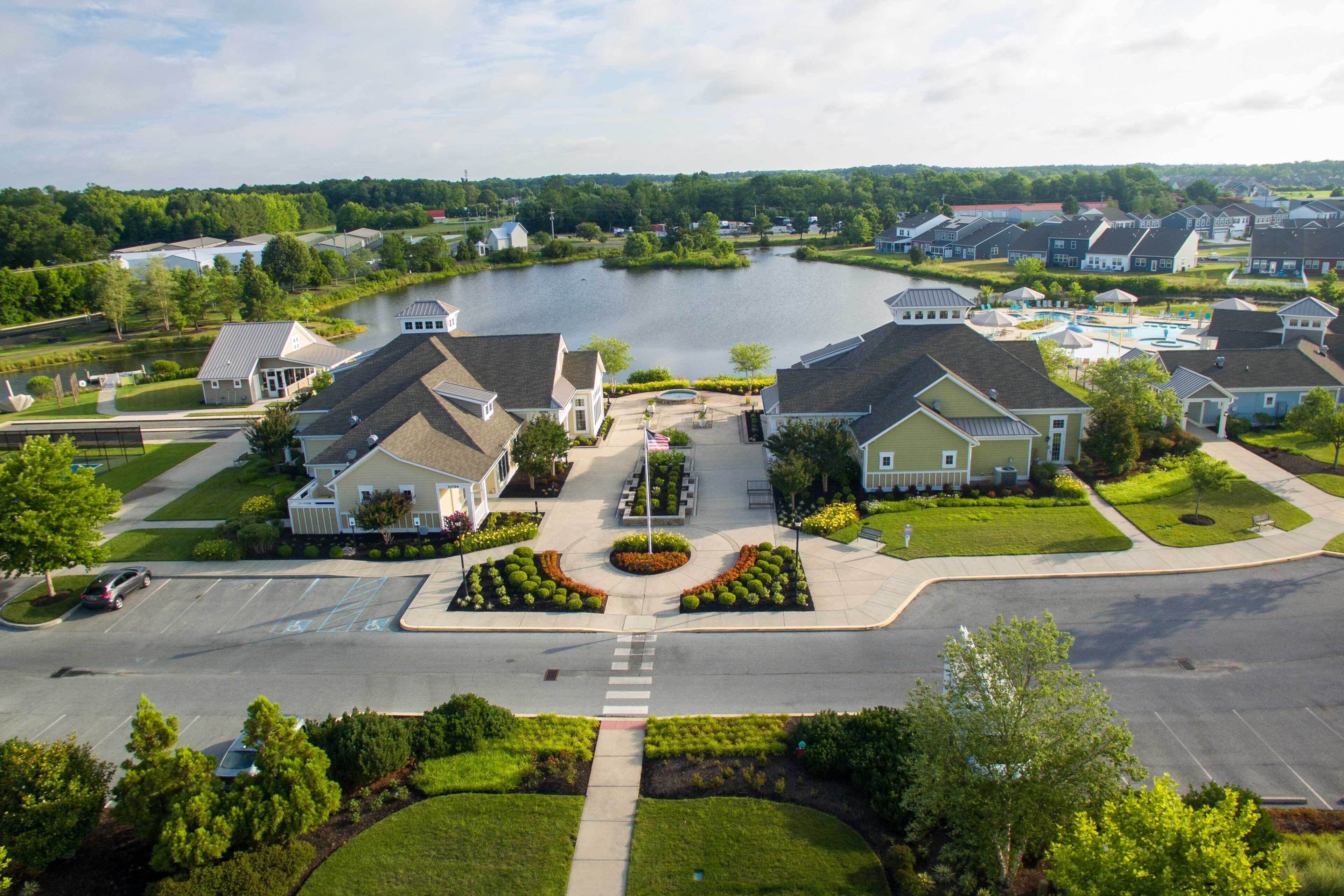 A residential area with houses, a central landscaped area, and a body of water.