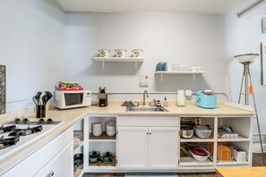 A compact kitchen with a microwave, sink, and various storage cabinets.
