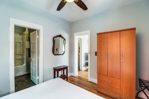 A bedroom with a bed, a wooden wardrobe, a mirror, and a door leading to a bathroom. - 'St Ceilia' Apt - Walk to Bisbee Attractions! (Bisbee)
