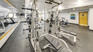 A gym with various exercise machines, a mirrored wall, and a door in the background. - Iron Horse Studio w/ Resort Amenities; Walk to WP! (Winter Park)
