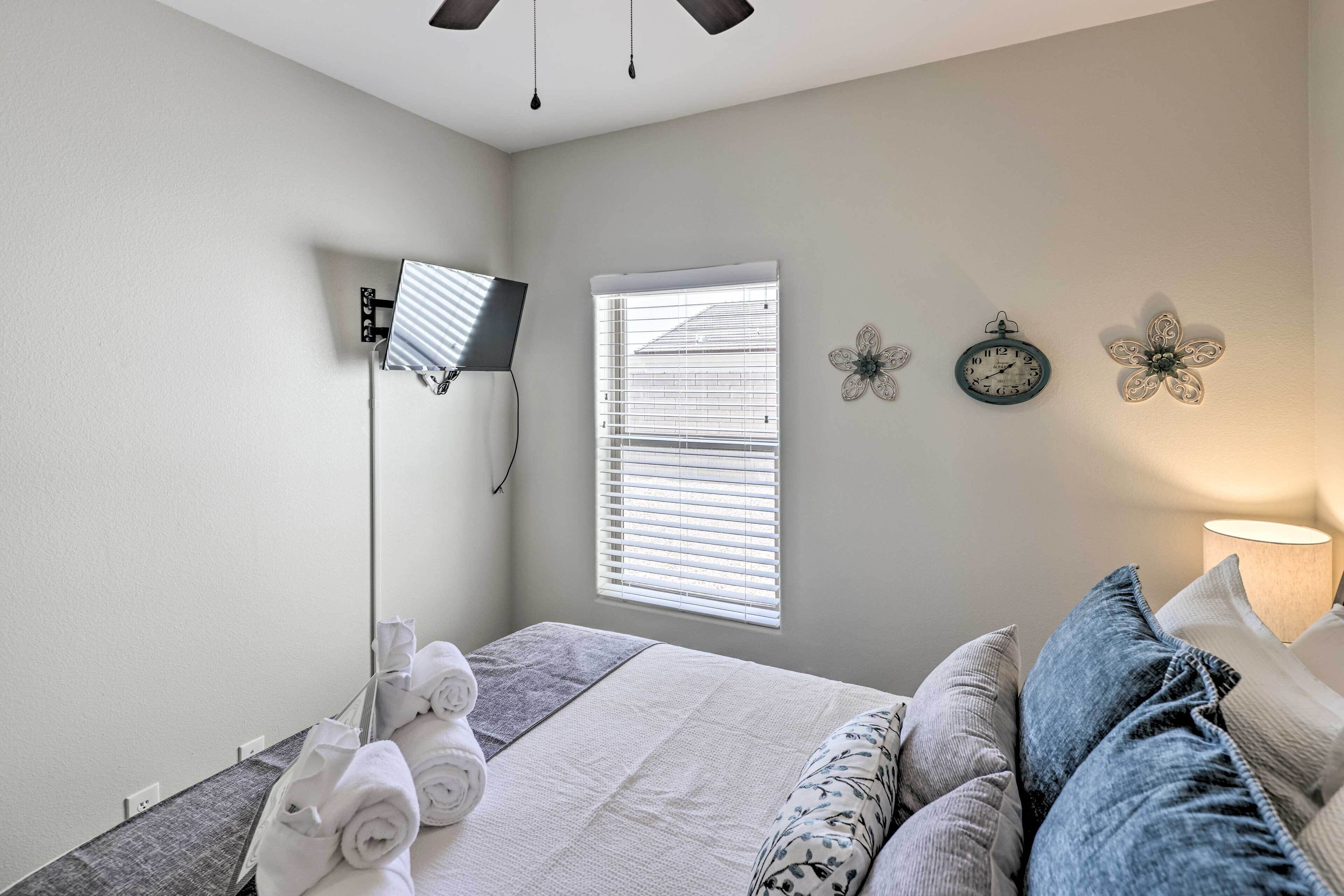Une chambre à coucher avec un lit, un bureau, une lampe et une fenêtre avec des stores.