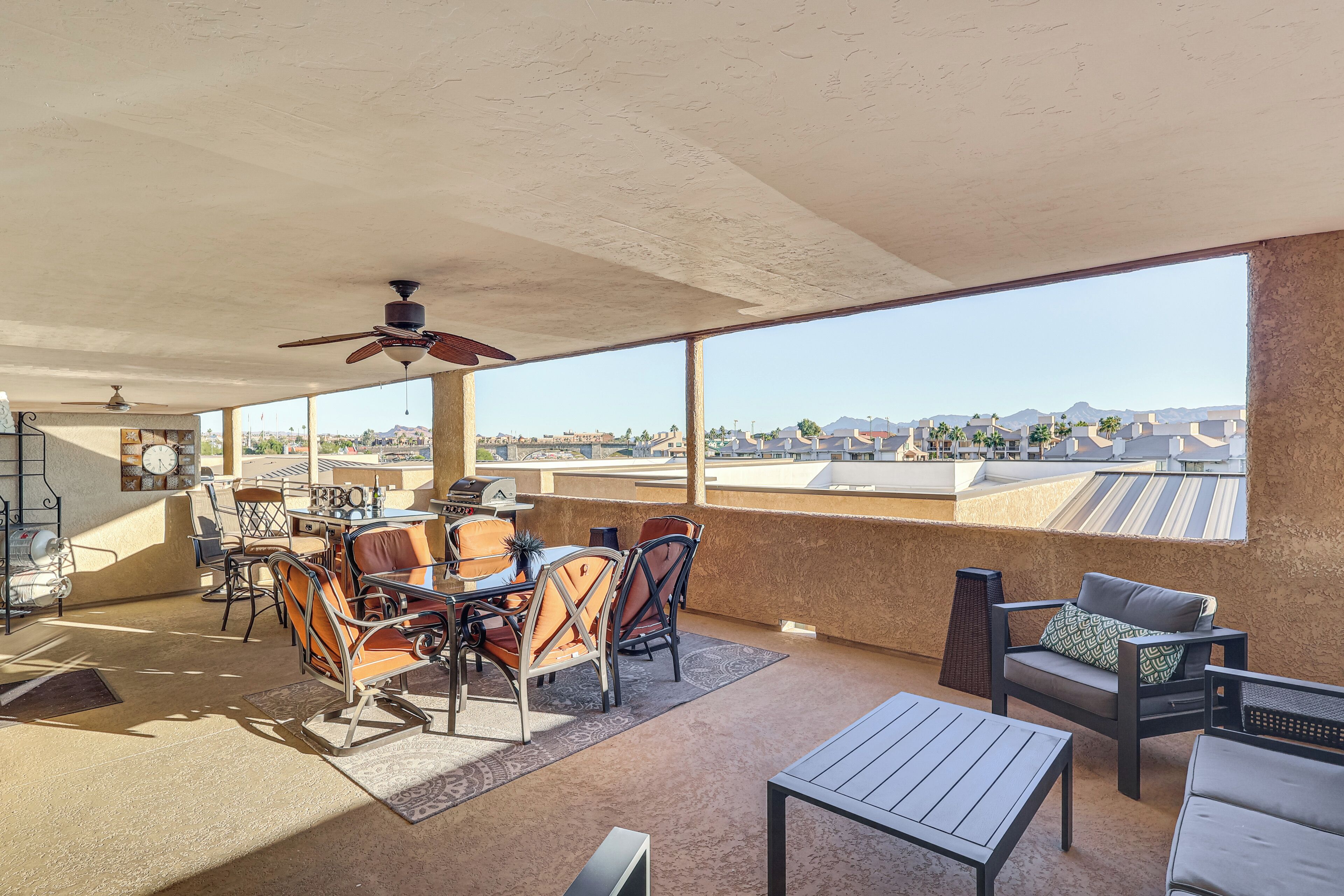 A spacious balcony with a dining area, chairs, and a table.
