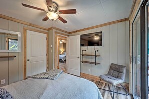 A bedroom with a bed, a ceiling fan, a TV mounted on the wall, and a chair by the window. - 1 Mi to Skiing: Beech Mountain Condo w/ Fireplace! (Banner Elk)