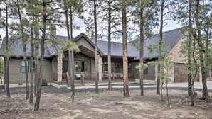 A cabin with a stone foundation, wooden exterior, and a covered porch. - Stylish Show Low House w/ Expansive Deck! (Show Low)