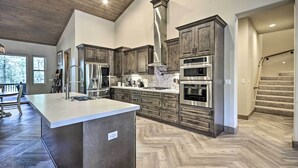 A spacious kitchen with wooden cabinets, stainless steel appliances, and a large island. - Stylish Show Low House w/ Expansive Deck! (Show Low)
