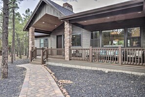 A modern house with a stone foundation, large windows, and a covered porch. - Stylish Show Low House w/ Expansive Deck! (Show Low)