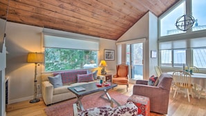 A cozy living room with a wooden ceiling, a sofa with plaid cushions, a coffee table, and a chair. - Spacious Village of Loon Home < 1 Mi to Ski Slopes (Lincoln)